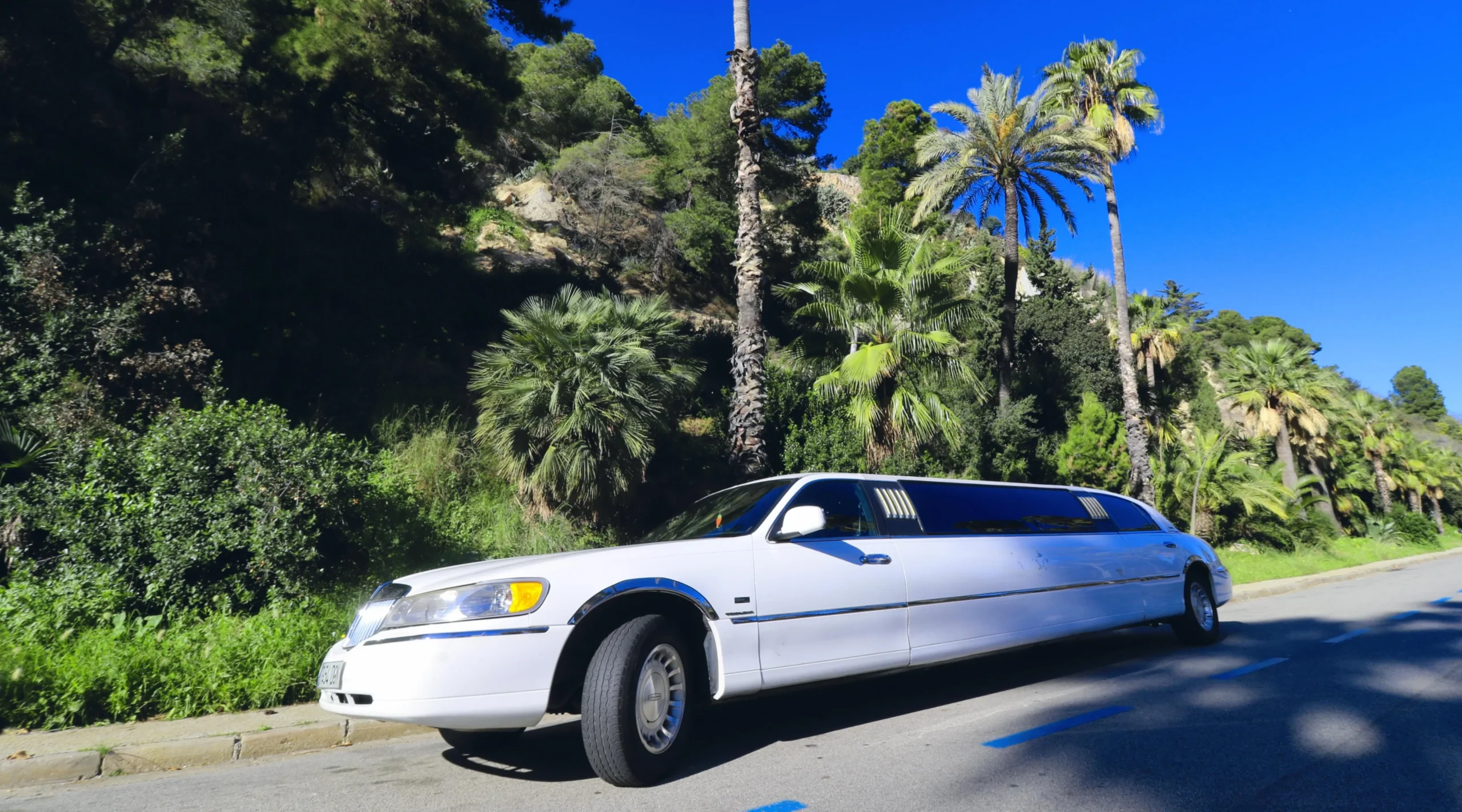 Vista frontal de una limusina Lincoln americana blanca, con diseño elegante y detalles clásicos. Ideal para eventos especiales con el servicio de alquiler de Limusinas en Barcelona.