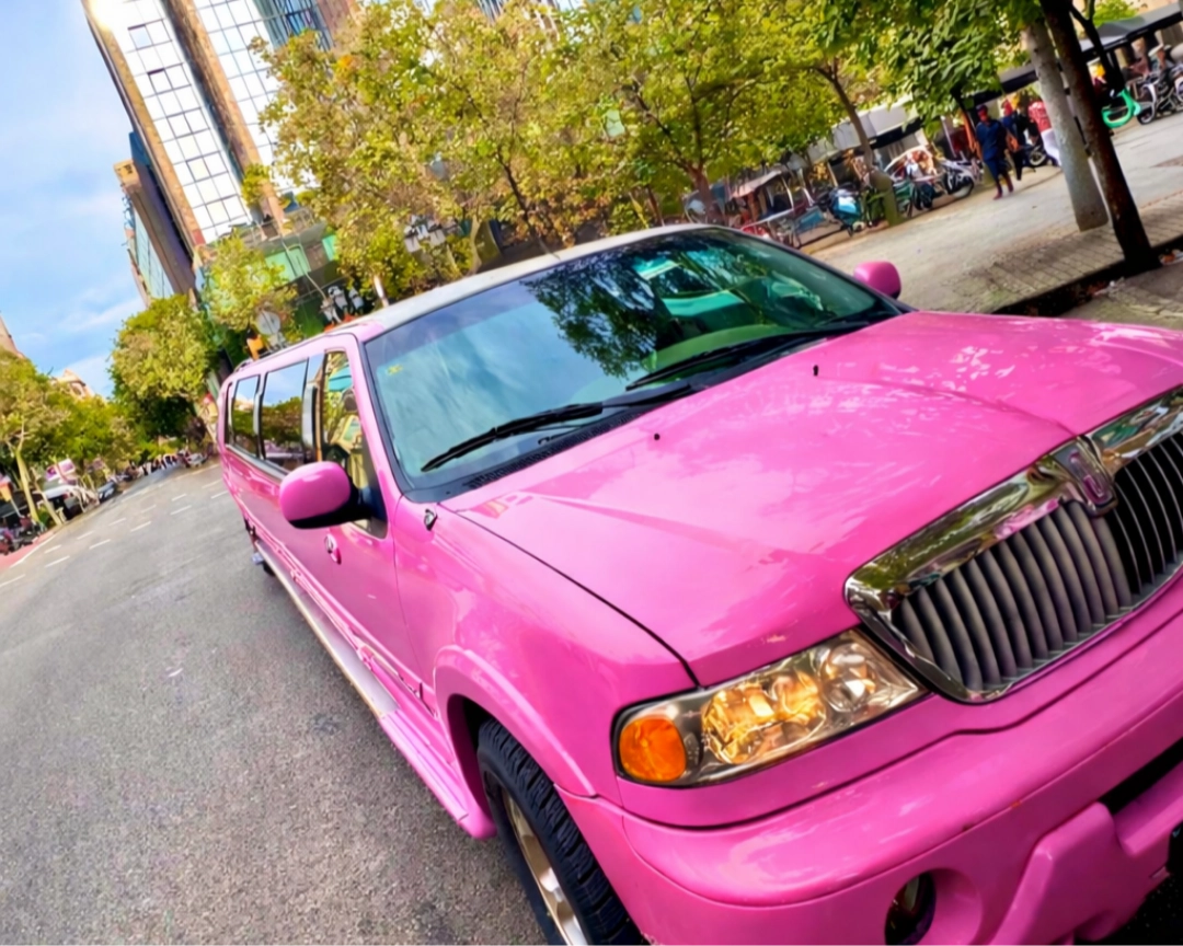 Limusina Hummer rosa en carretera de Barcelona con vistas a la ciudad – alquiler de limusinas rosas en Barcelona