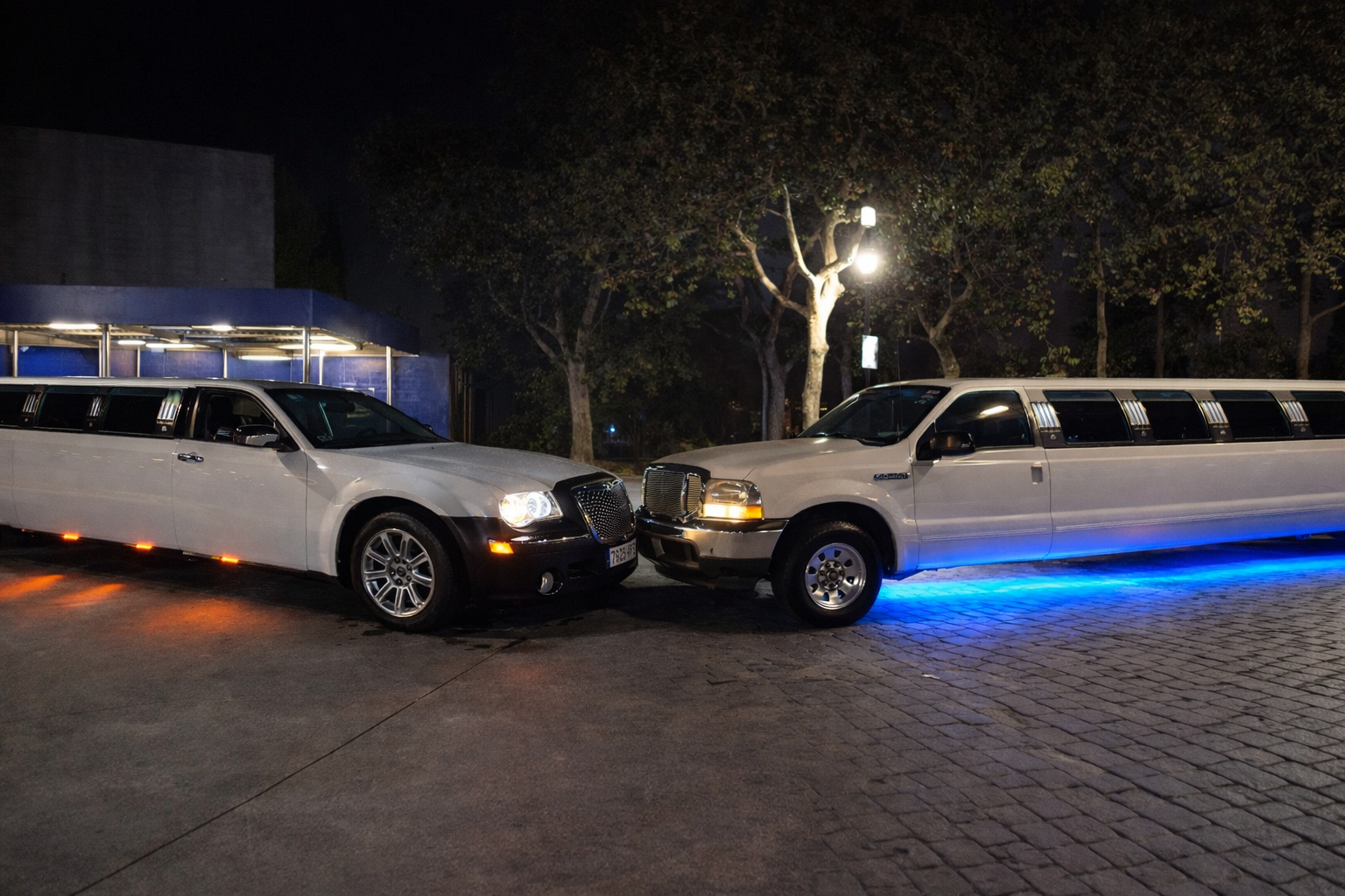 dos limusinas una blanca y otra blanca alt="Dos limusinas blancas de lujo en Barcelona con capacidad para 15 personas, perfectas para celebraciones y eventos especiales"