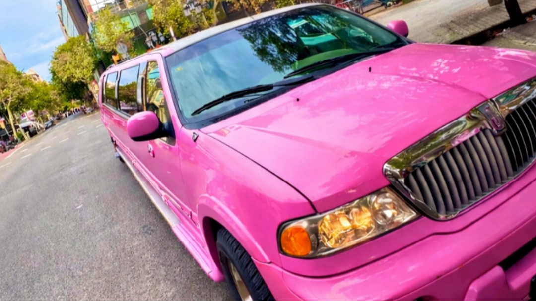 limusina hummer rosa Barcelona Limusina Hummer rosa circulando por una carretera de Barcelona con edificios emblemáticos de la ciudad al fondo