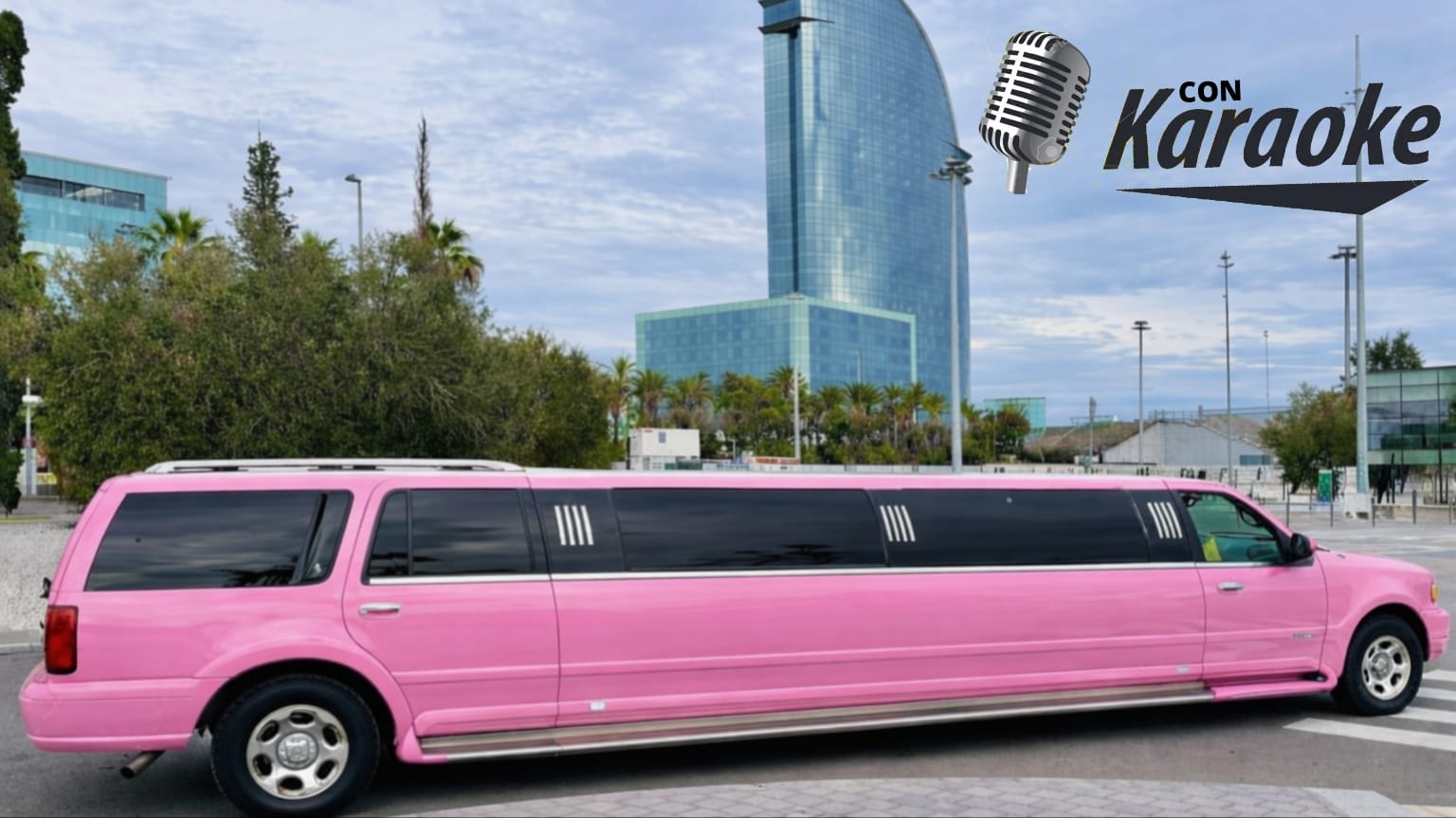 Made with LogoLicious Add Your Logo App Limusina Hummer rosa en la ciudad de Barcelona equipada con karaoke y luces interiores, preparada para celebraciones y eventos especiales.